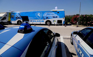 Il pullman azzurro della Polizia nella piazza dell’omicidio di Porto Sant’Elpidio
